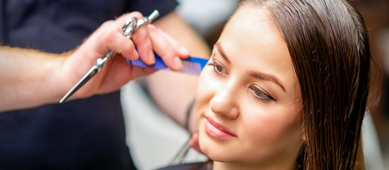 Styling female hair. Male hairdresser makes hairstyle for a young woman in a beauty salon. photo