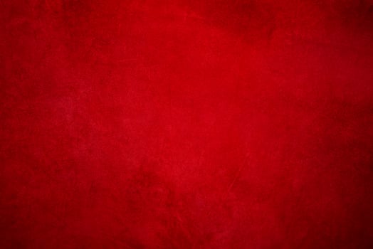 Suede background with small scratches, light red in the center and dark around the edges. photo