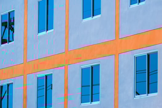 Low angle and side view of blue sky reflection on glass windows surface of modern building wall photo