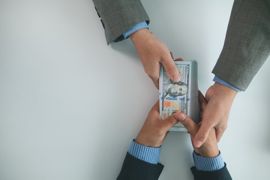 Real estate brokers are bribing government officials with cash issue construction permits in areas where high rise buildings are prohibited. Concept bribing government officials to facilitate business photo