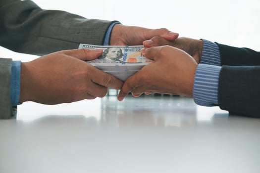 Real estate brokers are bribing government officials with cash issue construction permits in areas where high rise buildings are prohibited. Concept bribing government officials to facilitate business photo