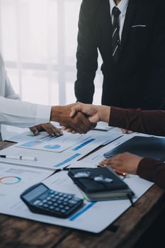 Real estate agent and customers shaking hands together celebrating finished contract after about home insurance and investment loan, handshake and successful deal. photo