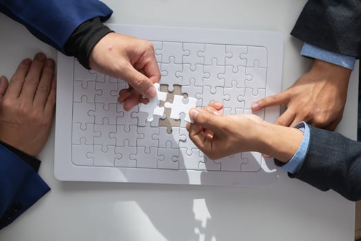 In hands of businessmen and investors they hold jigsaw pieces to put together in right way to make the jigsaw pieces symbolize their participation in business ventures. Venture capital symbol concept photo