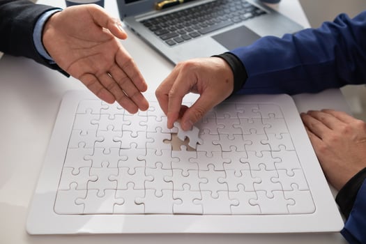 In hands of businessmen and investors they hold jigsaw pieces to put together in right way to make the jigsaw pieces symbolize their participation in business ventures. Venture capital symbol concept photo