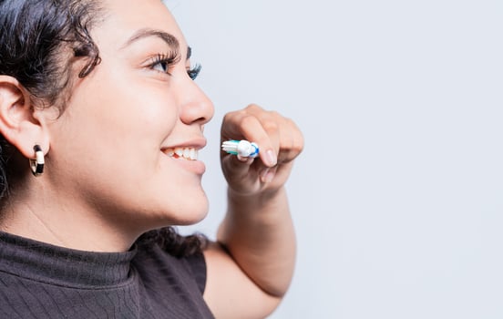 Smiling woman brushing his teeth isolated with copy space. Face of young woman brushing teeth isolated. Oral and dental smile concept photo