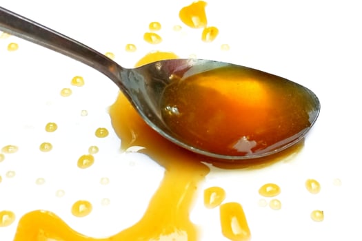 Spoon of honey isolated on white background photo