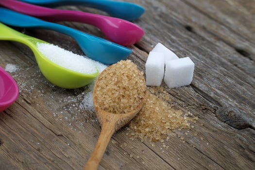 Brown cane sugar and white sugar in measuring spoons photo