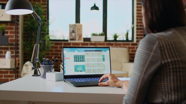 Remote stockholder analyzing investment financial profit by looking at market shares graphs. Professional broker investor checking stock exchange valuation while working from home, camera A photo
