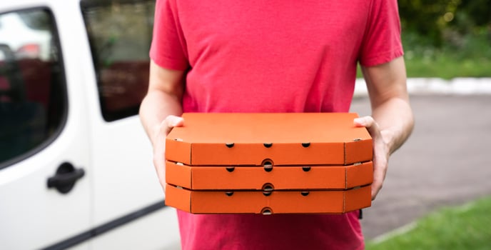 Man's hands hold pizza boxes. Pizza delivery. Online orders. Selective focus. photo