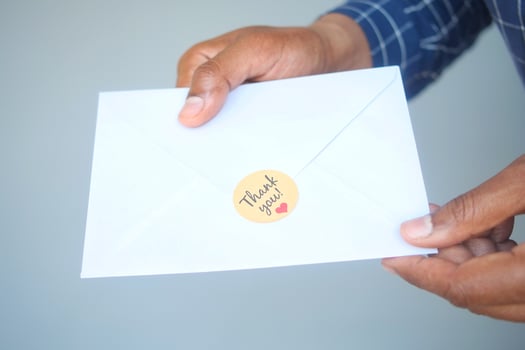 close up of man hand reading a thank you letter photo