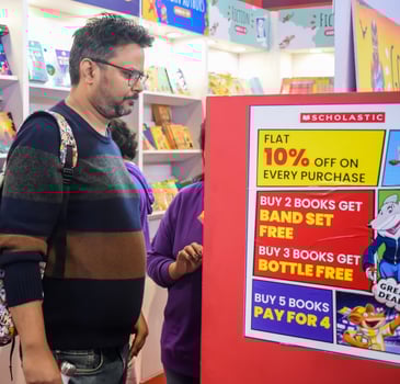 Delhi, India, February 17 2024 - Various age group people reading variety of Books on shelf inside a book-stall at Delhi International Book Fair, Books in Annual Book Fair at Bharat Mandapam complex photo