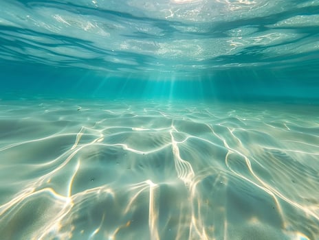 AI generated A beautiful underwater view of the clear, turquoise ocean with a sandy bottom and rays of sunlight filtering through the water. The light reflects off the calm waters photo