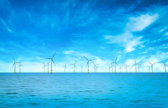 Offshore Wind Turbine in a Windfarm under construction off the England Coast at blue sky photo
