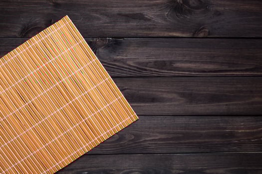 Bamboo mat on wooden table, top view photo
