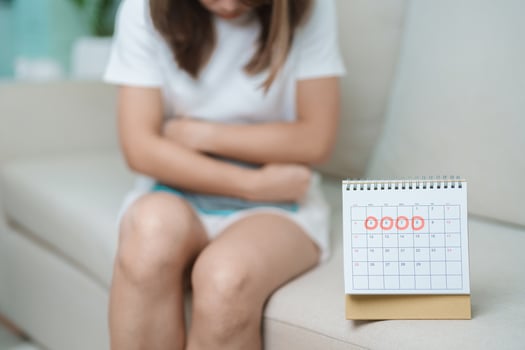 Menstruation period cycle of monthly and Stomachache concepts. woman having abdomen pain with hot water bottle and calendar, illness female suffer from premenstrual ache and body Health problem photo