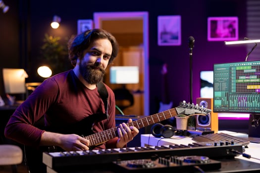 Portrait of confident artist playing acoustic guitar in his home studio, prepares for a new audio recording session to edit tracks for music industry. Songwriter guitarist composing songs. photo