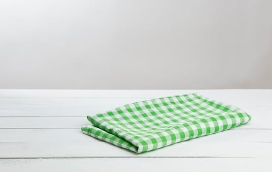 White wooden table with green tablecloth for product montage photo
