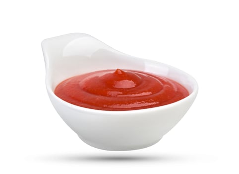 Bowl of tomato ketchup isolated on white photo
