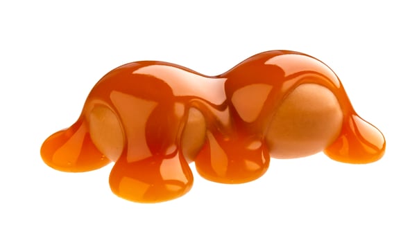 Caramel candies and caramel sauce isolated on white background photo