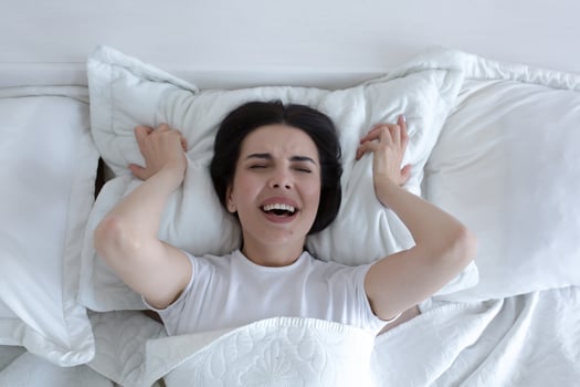 Top view, depressed woman lying in bed crying and screaming with sadness. photo