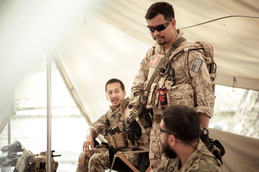 Soldiers in camouflage uniforms planning on operation in the camp, soldiers training in a military operation photo