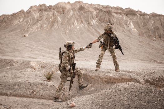 Soldiers in camouflage uniforms aiming with their riflesready to fire during military operation in the desert soldiers training in a military operation photo