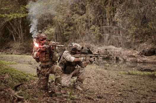 Soldiers in camouflage uniforms aiming with their riflesready to fire during Military Operation in the forest soldiers training in a military operation photo