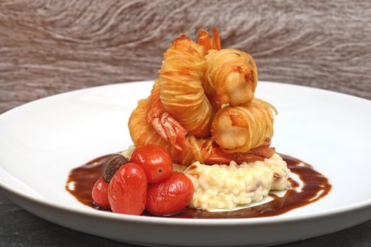 fried prawns with straw potatoes, cheese risotto and sauce photo