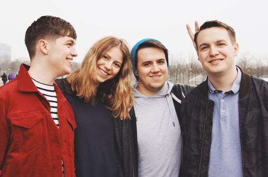 group of young friends posing arm in arm photo