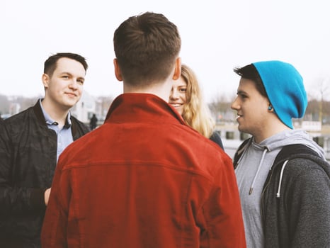 group of teenage friends talking and laughing together photo
