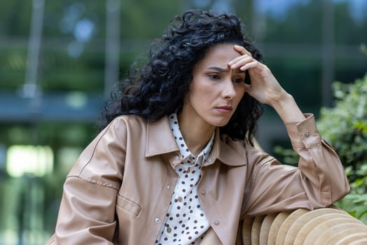 Depressed mature adult woman sitting on bench outside office building, businesswoman boss upset and disappointed with results of achievement at work, bankruptcy and financial loss economic crisis. photo