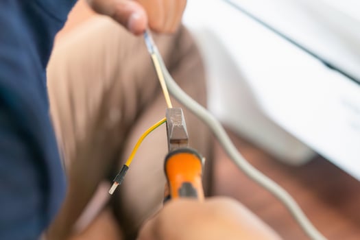 Technician man cutting electrical wires with pliers for installing new air conditioning, repair service air conditioner photo