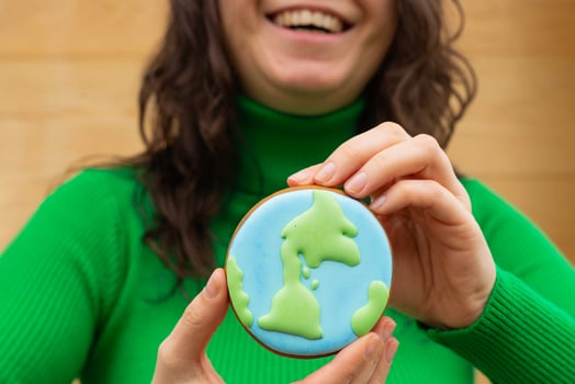 Earth Day concept. Gingerbread in the shape of a planet in the hands of a woman. photo