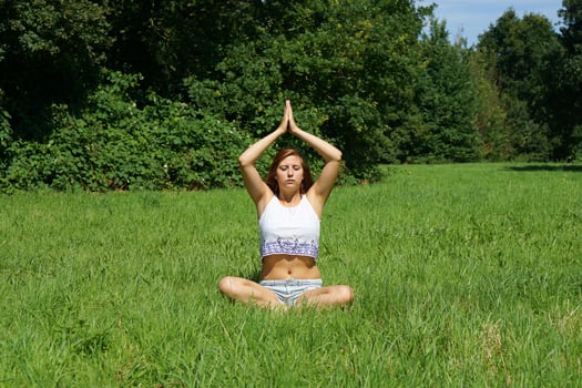 young woman practicing yoga meditation outdoors photo