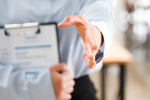 Businessperson's hand outstretched for a handshake, signaling readiness to engage. photo