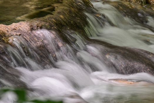 Mountain stream in the forest - long exposure and flowing water photo