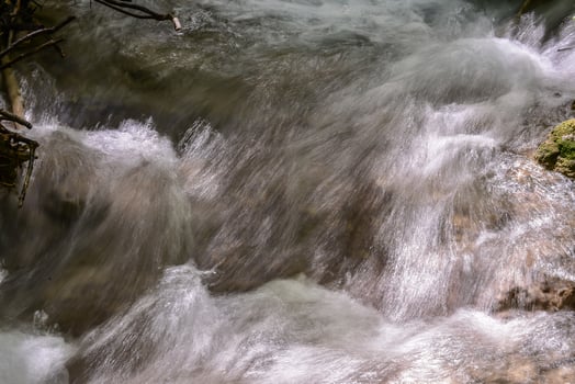 Mountain stream in the forest - long exposure and flowing water photo