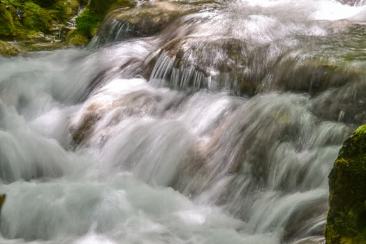 Mountain stream in the forest - long exposure and flowing water photo