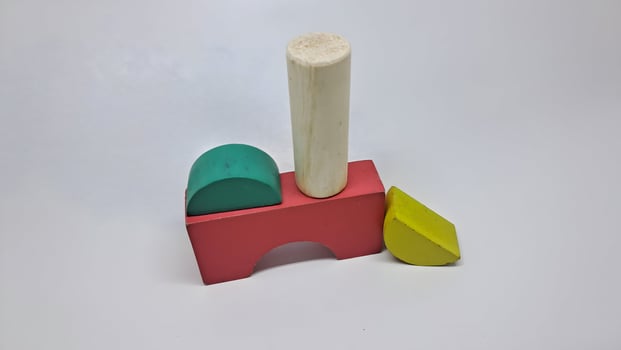 a wooden toy with a green, yellow and pink piece photo