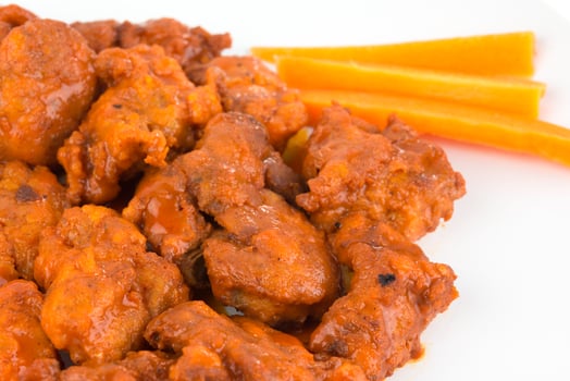 Boneless chicken wings with buffalo sauce and carrots photo