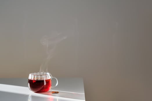 Glass mug with hot black tea on the table. photo