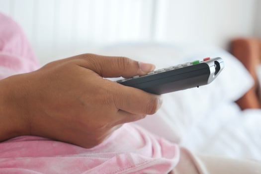 close up of women hand holding tv remote. photo