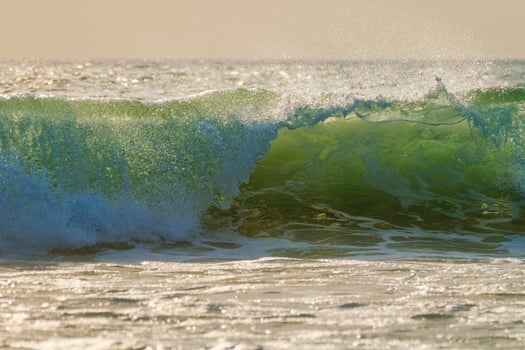 Breaking ocean wave on sunset photo