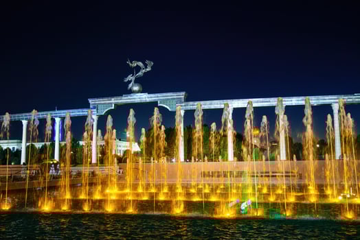 Memorial and rows of fountains with illumination in the Independence Square at summertime in nighttime, Tashkent, Uzbekistan. photo