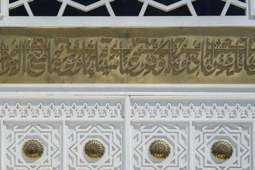 Fragment of white carved antique wooden doors with patterns, golden metal jewelry and mosaics. photo