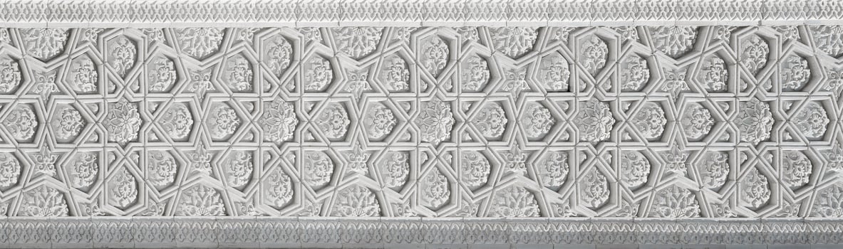 Geometric traditional Islamic ornament. Fragment of a carved mosaic on white marble. photo