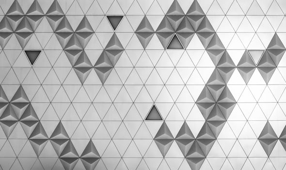 Steel diamond-shaped polished metal cladding panels of a modern building. Abstract monochrome background. photo