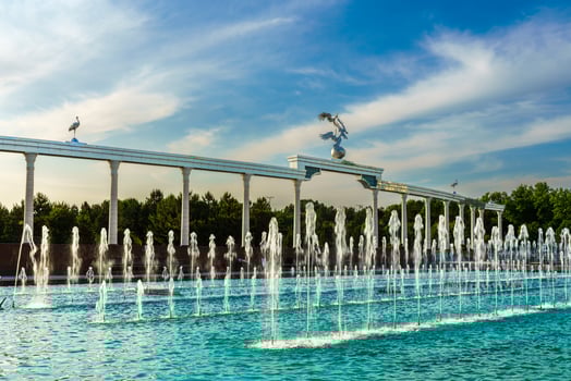 Memorial and rows of fountains illuminated by sunlight at sunset or sunrise in the Independence Square at summertime, Tashkent. photo