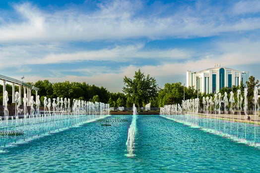 Memorial and rows of fountains illuminated by sunlight at sunset or sunrise in the Independence Square at summertime, Tashkent. photo