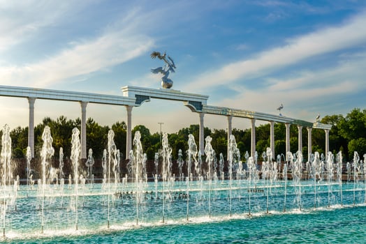 Memorial and rows of fountains illuminated by sunlight at sunset or sunrise in the Independence Square at summertime, Tashkent. photo